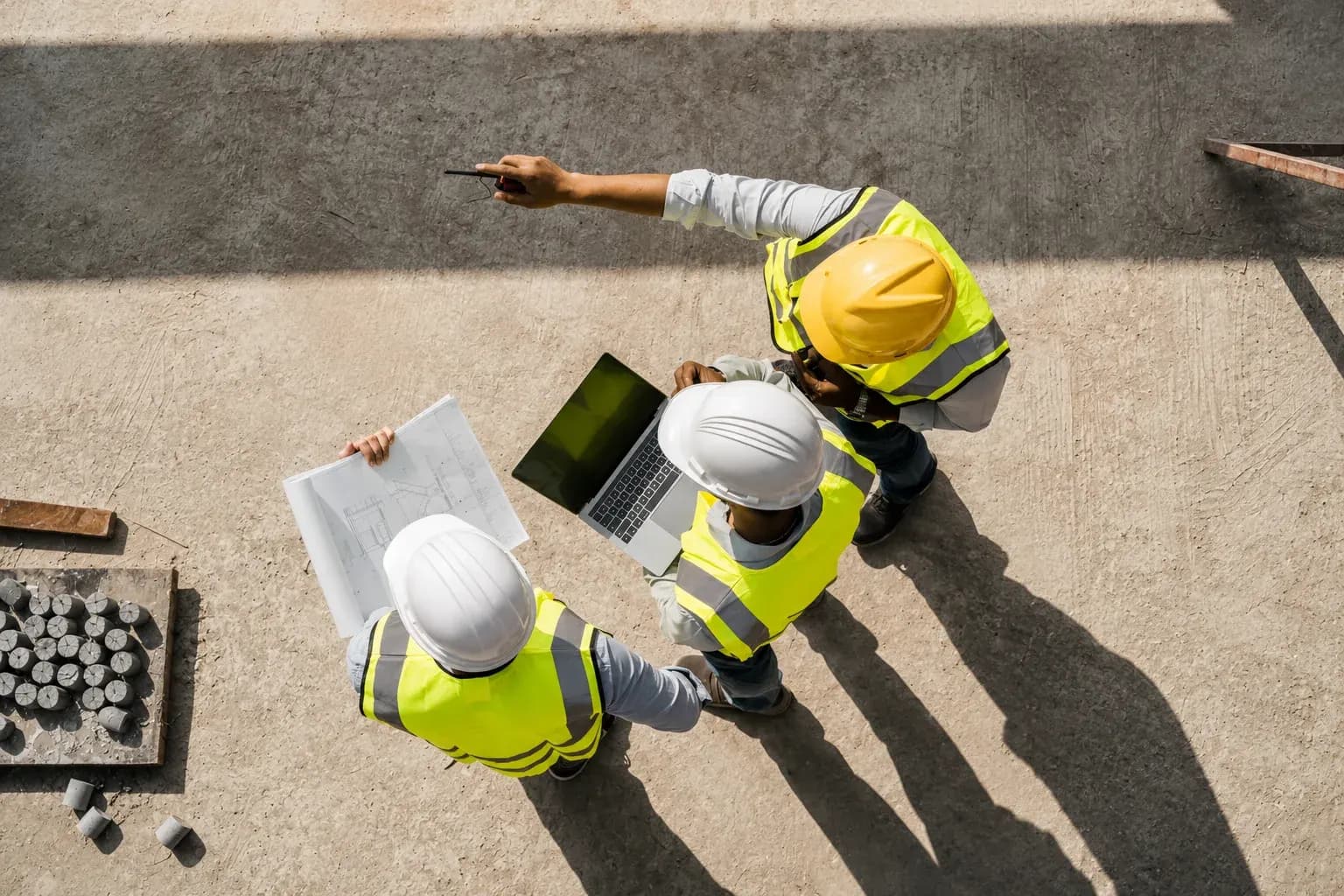 Équipe de chantier BTP en PACA avec plans et ordinateur
