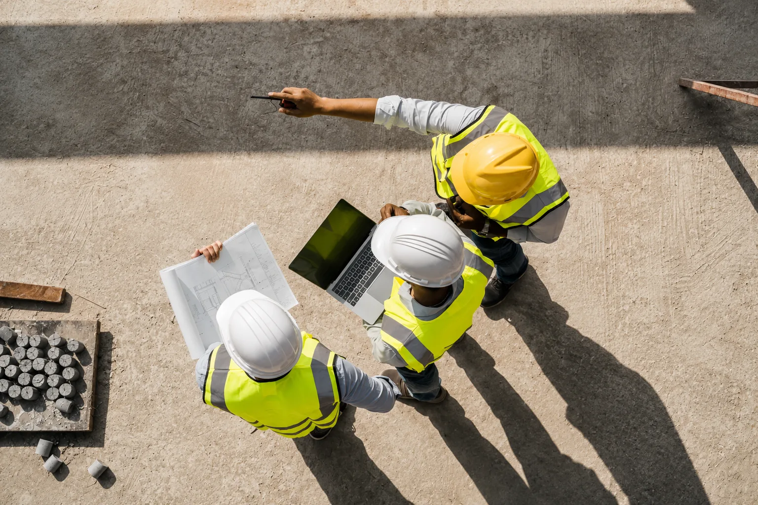 Équipe de chantier BTP en PACA avec plans et ordinateur